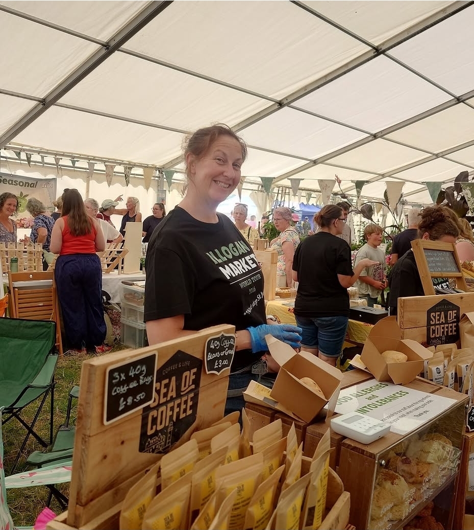 Stallholder serving customers at the Sea of Coffee stall inside the marquee