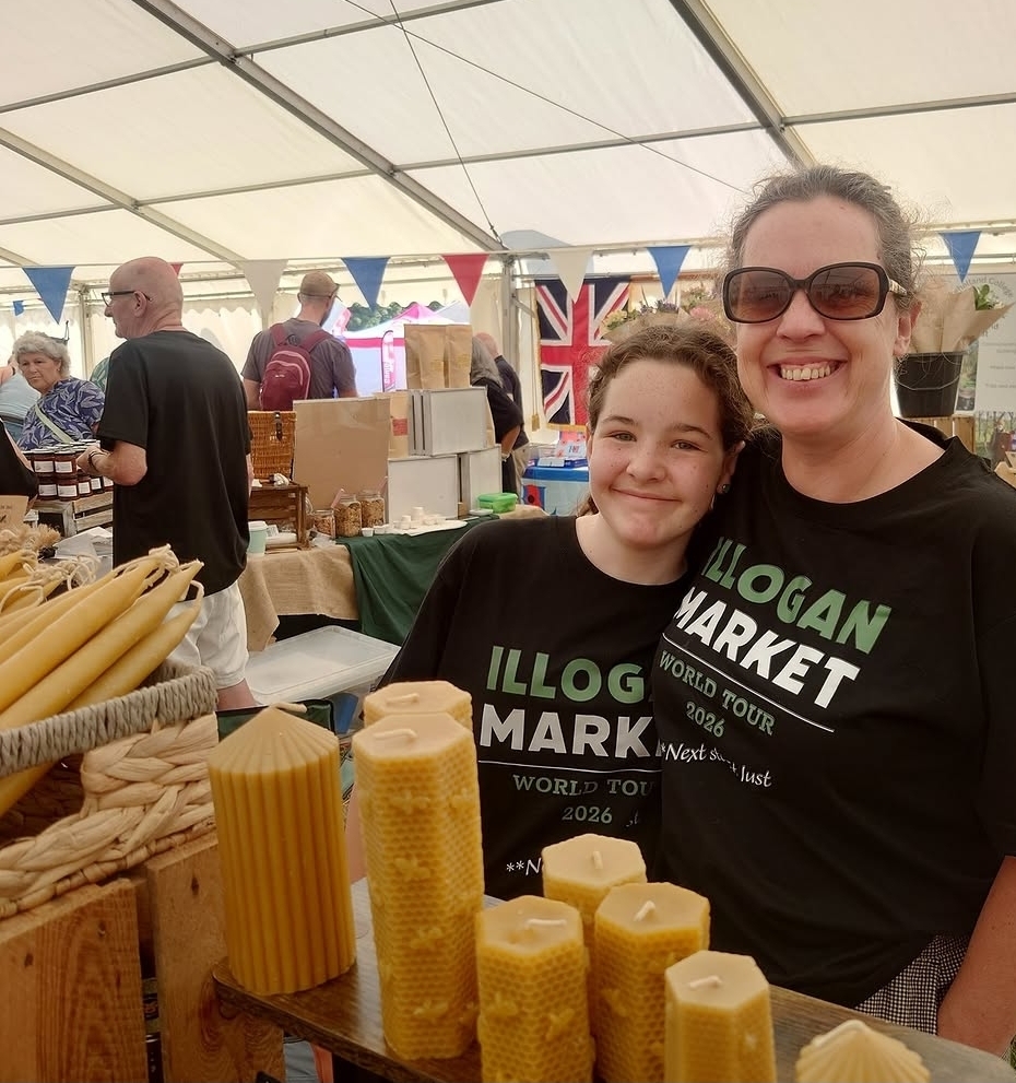 Two stallholders behind a display of handmade beeswax candles