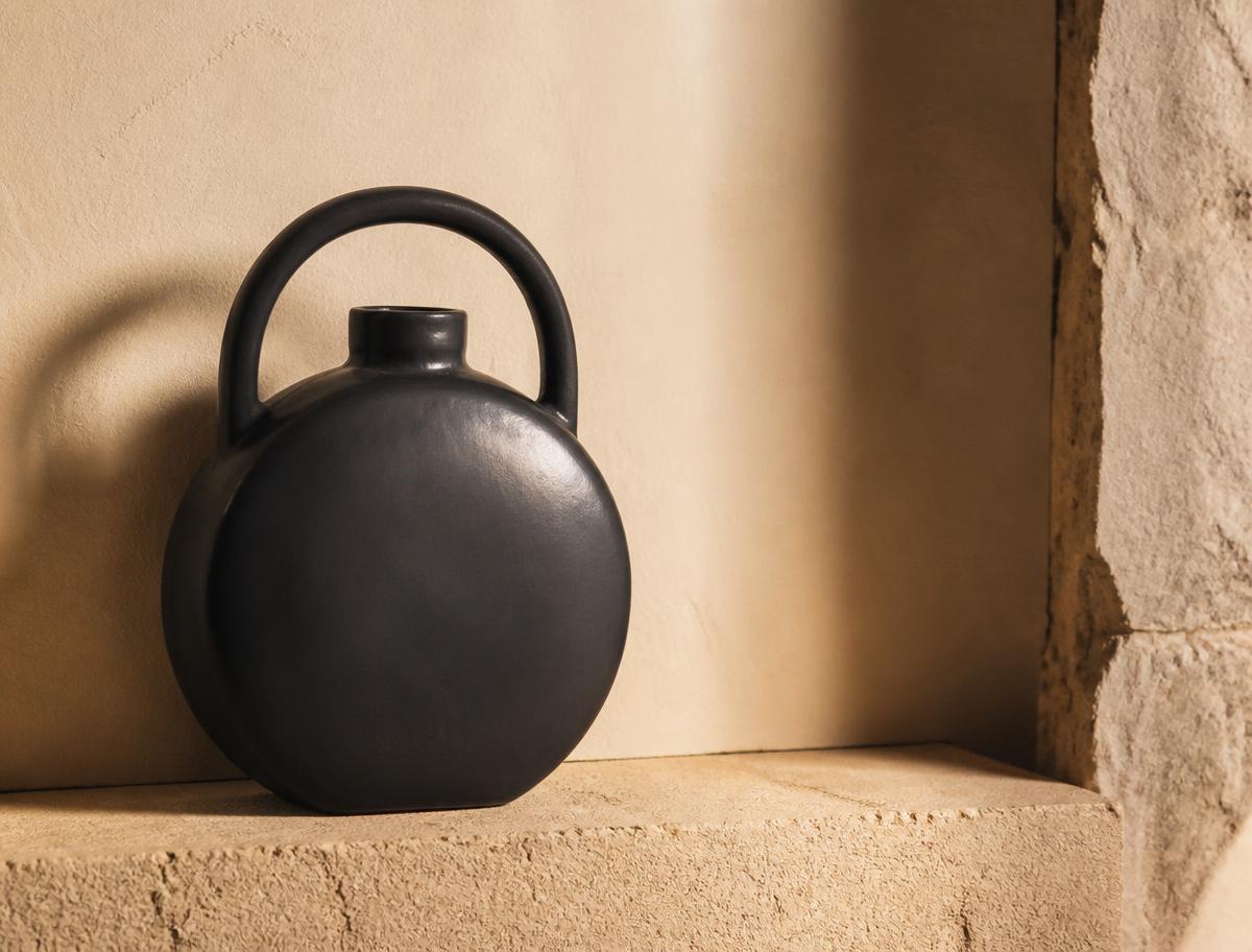 Dark circular handled ceramic vessel